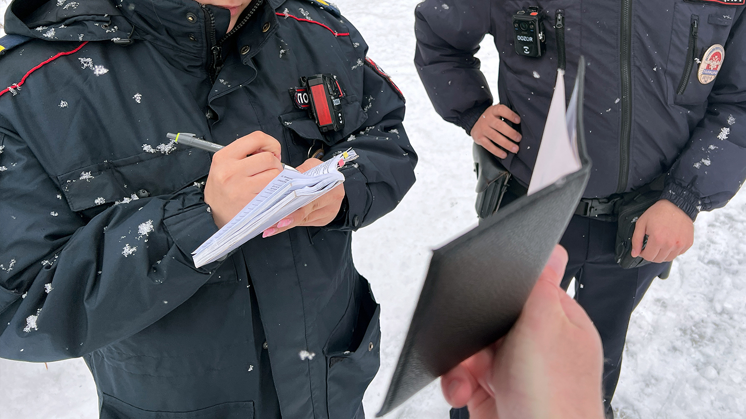 Tomsk police record Denis Karagodin’s personal data at the site of the dismantled memorial after stopping him for photographing the area.