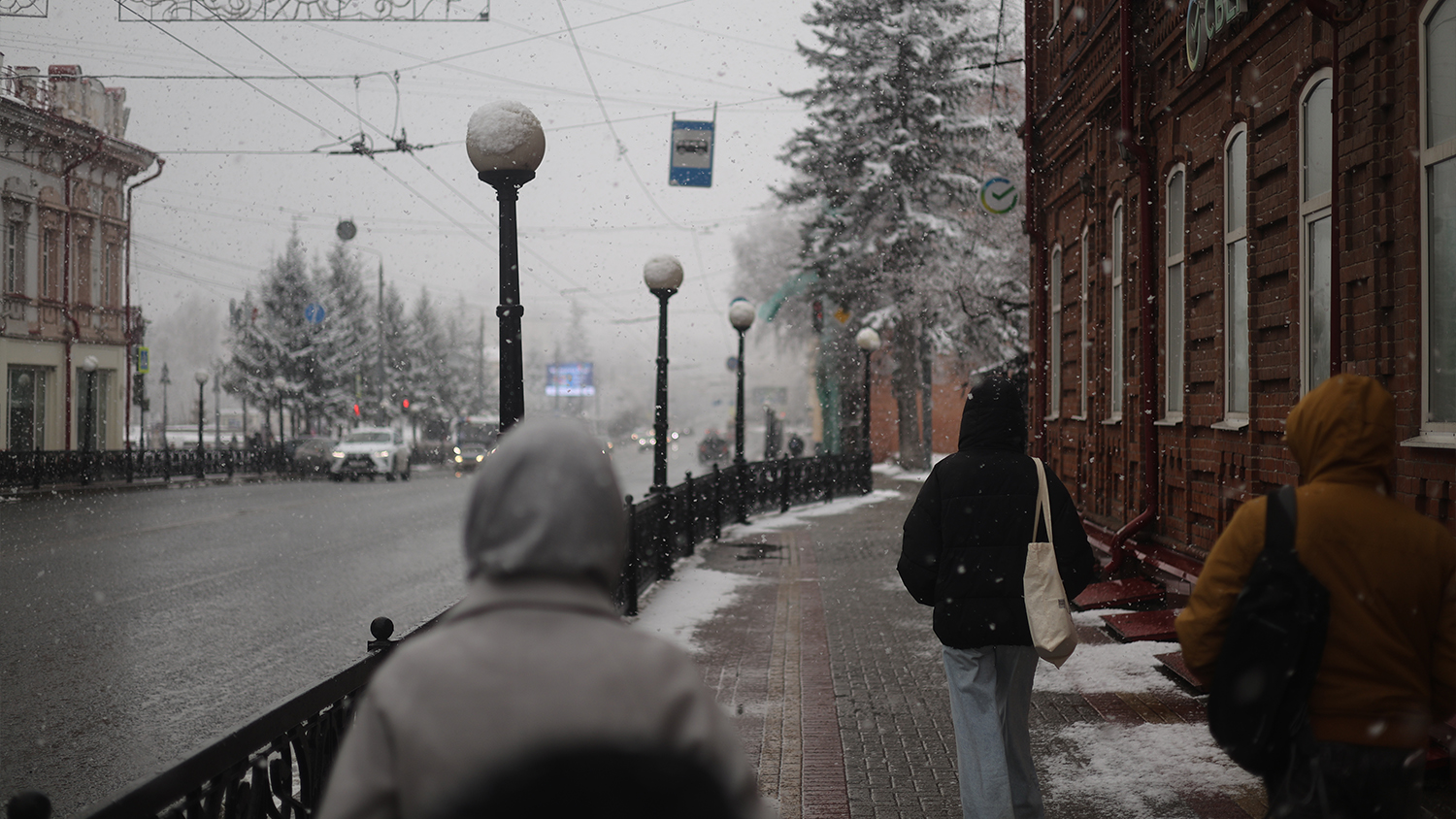 A central street in Tomsk, with pedestrians passing by; just around the corner to the right is the site of the dismantled memorial.